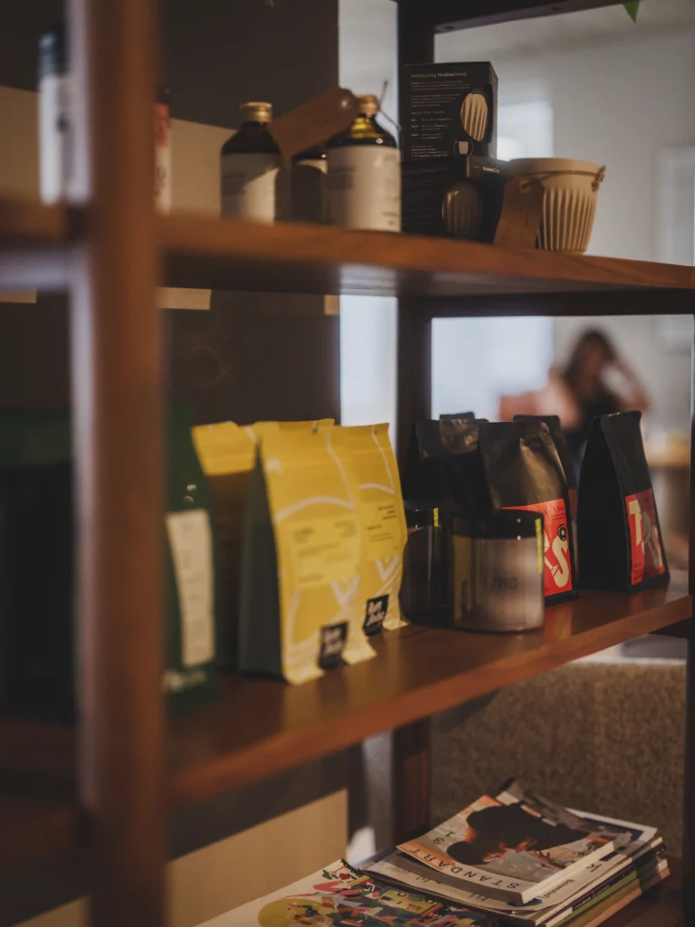 Estantería de una tienda con bolsas de café de distintos colores y frascos de vidrio