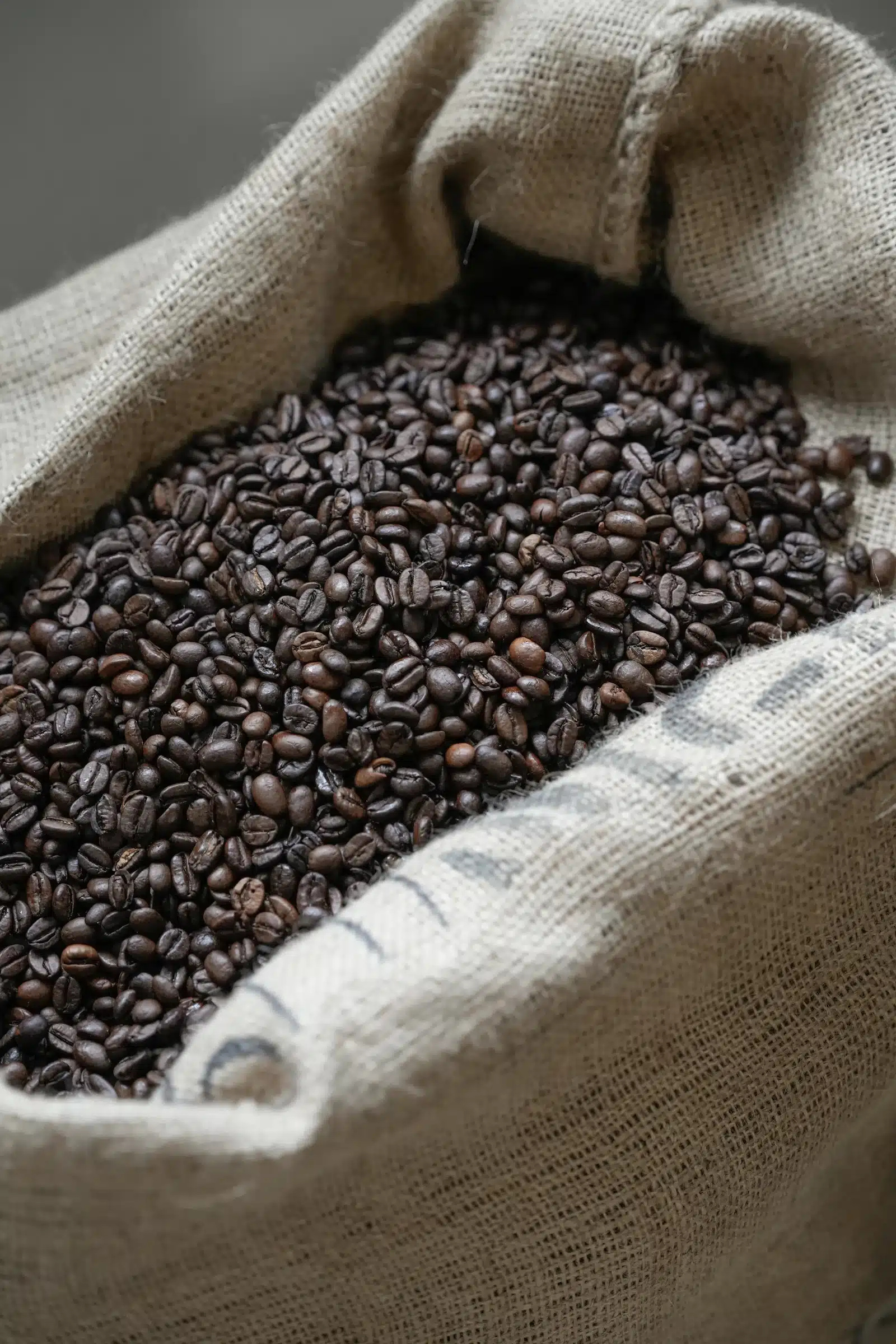 Costal de fique lleno de granos de café tostado, visto de cerca