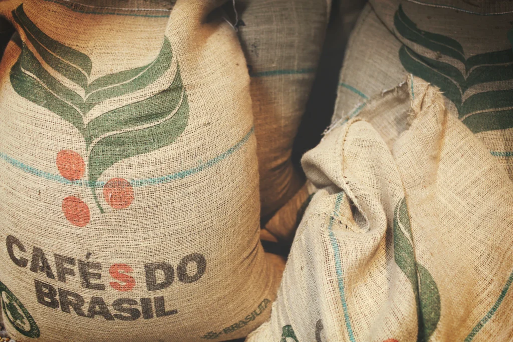 Sacos de yute apilados con la inscripción Cafés do Brasil, de los que se usan para transportar café